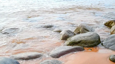Rocky seashore. Large and small boulders on the beach. Waves at sea. Stock Footage 153010398