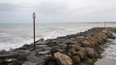 Rocky Seashore with Waves and No Smoking Sign Stockbeeldmateriaal 345276544