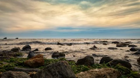 Rocky seashore with waves cloudy sky Stock Photos