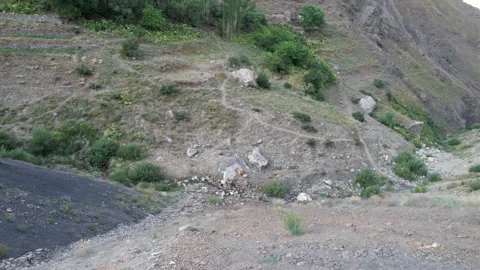 Rocky Shem hillside close-up shows loose stone, sparse plants, and dry Stock Footage 343805360