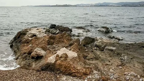 Rocky shore with small waves in winter, sky with clouds Stock Footage 128126818