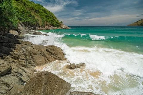 Rocky shore washed by a large sea turquoise wave. Summer vacation and nature Stock Photos