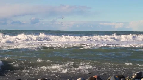 Rocky shore on which large waves beat and bubble on the horizon line Video stock 169809953