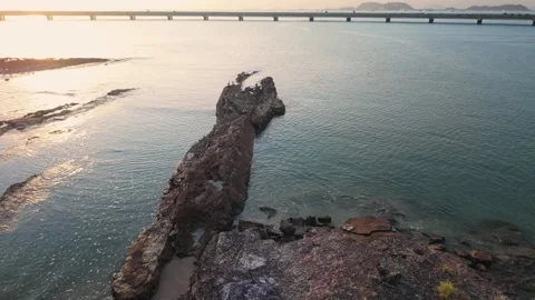 A rocky shoreline with a bridge in the background Stock Footage 326962128