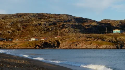 A rocky, steep seashore with a small, outdated settlement on it. Slow motion Stock Footage 297235909