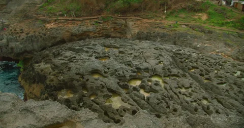Rocky tide pools carved into limestone shore at Angels Billabong beach in Nusa Stock Footage 344918756