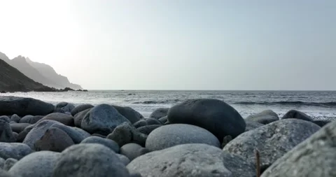 Rocky volcanic beach surrounded by high mountains and cliffs still steady view Stock Footage 171311019