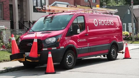 Rogers cable internet red work van parked at side of road with pylons around it Stock Footage 247753560