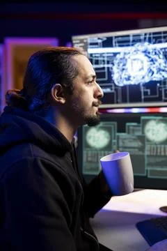 Rogue programmer holding coffee mug uses AI deep learning to develop exploit Stock Photos