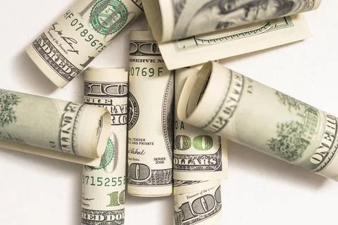 Roles dollar notes in front of white background Stock Photos