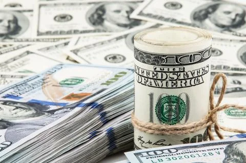 Roll of American dollars and a pack of dollars on the background of hundred d Stock Photos