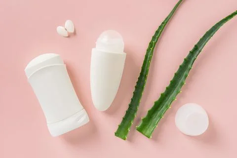 Roll on antiperspirant, solid deodorant and two fresh green aloe leaves. 스톡 사진