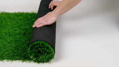 Roll of artificial green grass on white background. Stock Footage 150990364