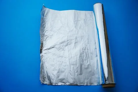 A roll of baking foil on a blue background. Foto stock