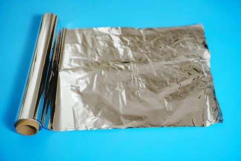 A roll of baking foil on a blue background. Stock Photos