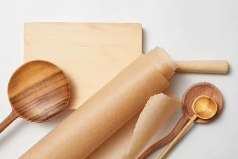 Roll baking paper and various wooden spoons Stock-Fotos