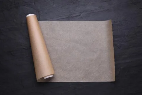 Roll of baking paper on black table, top view Stock Photos
