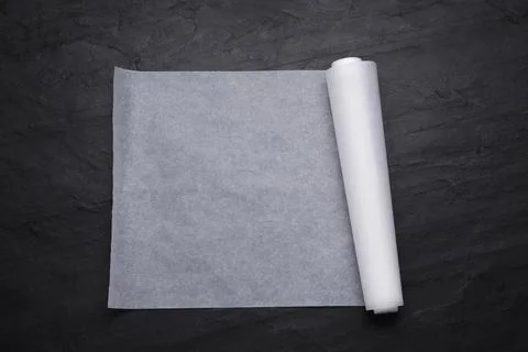 Roll of baking paper on black table, top view Stock Photos