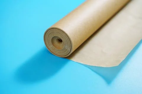 A roll of baking paper on a blue background. Stock Photos