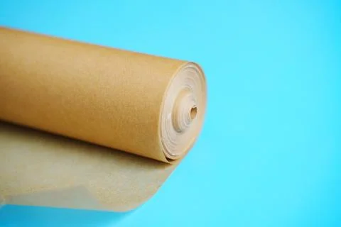 A roll of baking paper on a blue background. Stock Photos