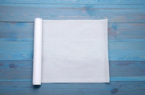 Roll of baking paper on light blue wooden table, top view Stock Photos