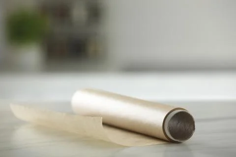 Roll of baking paper on white marble table against blurred background indoors Stock Photos