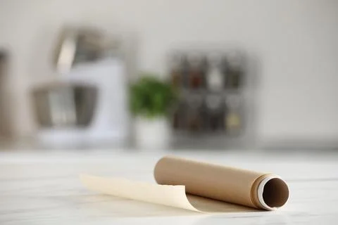 Roll of baking paper on white marble table against blurred background indoo.. Stock Photos