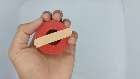 Roll of brown plaster for wound dressing with a red container Stock Photos