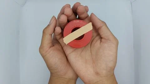 Roll of brown plaster for wound dressing with a red container Stock Photos