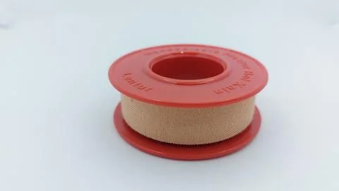 Roll of brown plaster for wound dressing with a red container Stock Photos