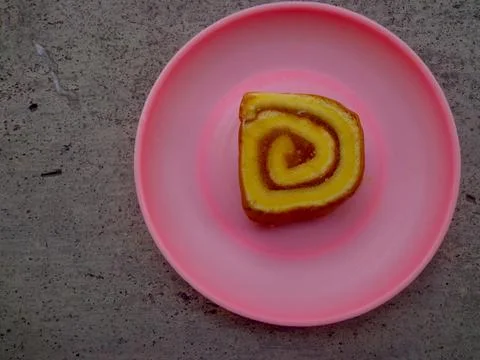 Roll cake served on a plastic plate Stock Photos