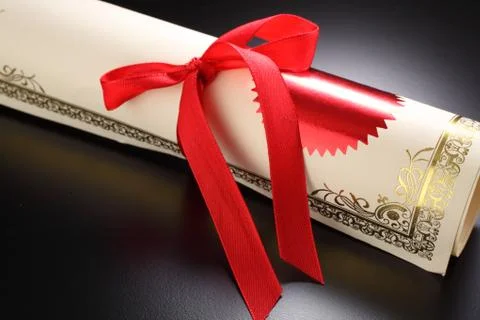 Roll of certificate on the black background Stock Photos