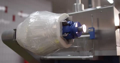 Roll of clear plastic packaging film mounted on a stainless steel wrapping Stock Footage 339974339