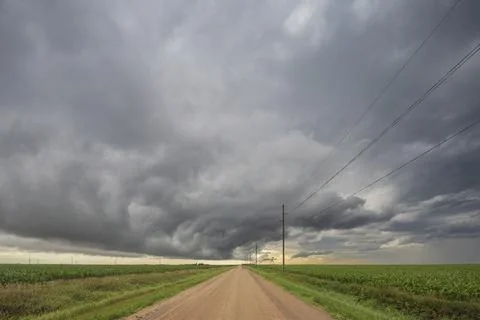 Roll cloud in the sky, a gatheriing storm over a dirt road, reaching to a b.. Stock Photos