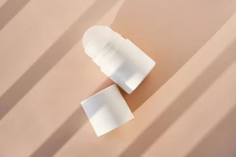 Roll-on deodorant on a purple background with shadow stripes. Stock Photos
