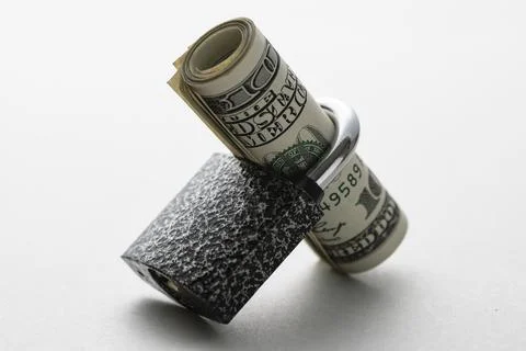 Roll of dollar bills through a padlock shank Stock Photos