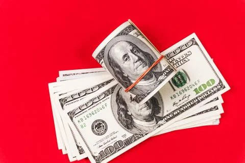 Roll dollars on a red background. Financial concept. Fotos de archivo