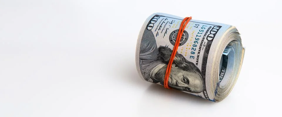 A roll of dollars on a white background. One hundred American dollar bills. Stock Photos
