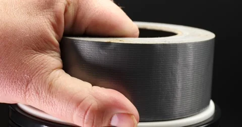 Roll a duct tape being picked up by man's hand then place back down isolated Vidéo 205439032