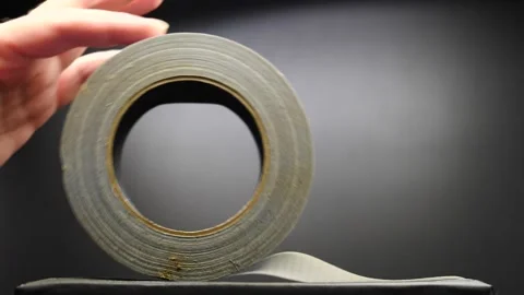 Roll of duct tape being rolled up when pushed in slow motion by hand isolated Vidéo 205439151