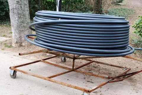 A roll of flexible plastic pipe for laying in the ground Stock Photos