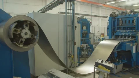 Roll of galvanized steel sheet feeds steel sheets to the cutting machine for Stock-Footage 153469788