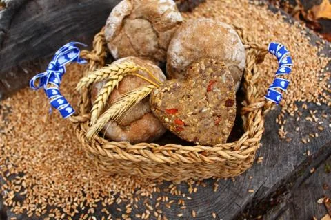 A roll with a heart shape in a basket on a tree trunk Stock Photos