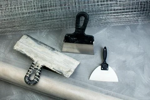 Roll mesh for plastering, putty knife on the gray concrete background. Copy s Stock Photos