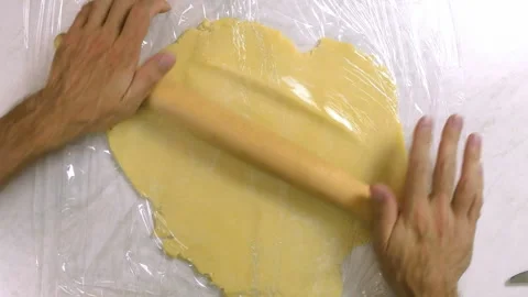 Roll out dough between two layers of clear film Stock Footage 100195338