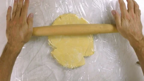 Roll out dough between two layers of clear film Stock Footage 100195517