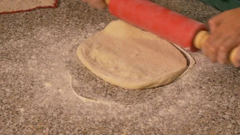 Roll out the dough with a rolling pin to prepare Italian pizza Stock Footage 95244027