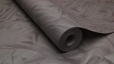 Roll of paper wallpaper on the wall with texture, camera movement slowly Stock Footage 306544193
