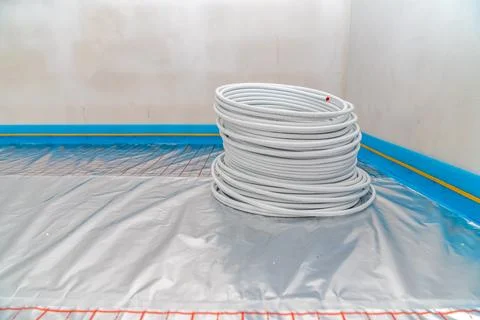 Roll with pipe for underfloor heating in a new building Fotos de archivo