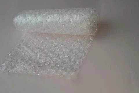 A roll of plastic bubble paper for packaging goods on a pink background clo.. Stock-Fotos